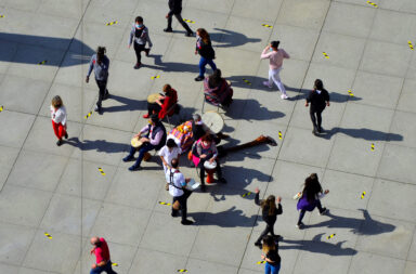 Grupo de pessoas em movimento numa praça vistas de cima para baixo