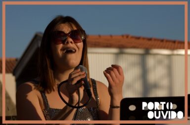 Mulher a cantar ao microfone com marca-de-água do programa Portouvido
