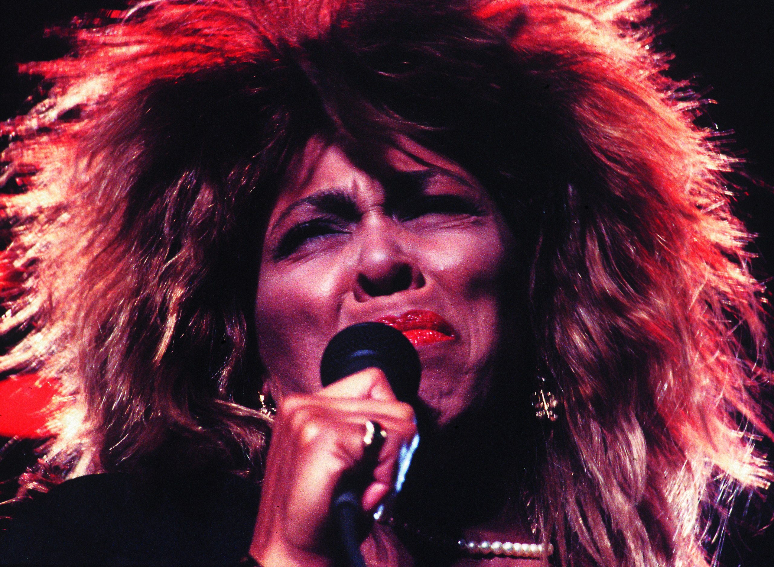 Rosto de Tina Turner enquanto atua em palco.